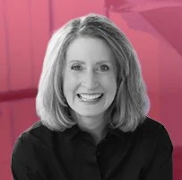 Joan Spiller, Director of Supply Chain Planning at Zefyr Consulting, smiling at camera with a pink overlay background.