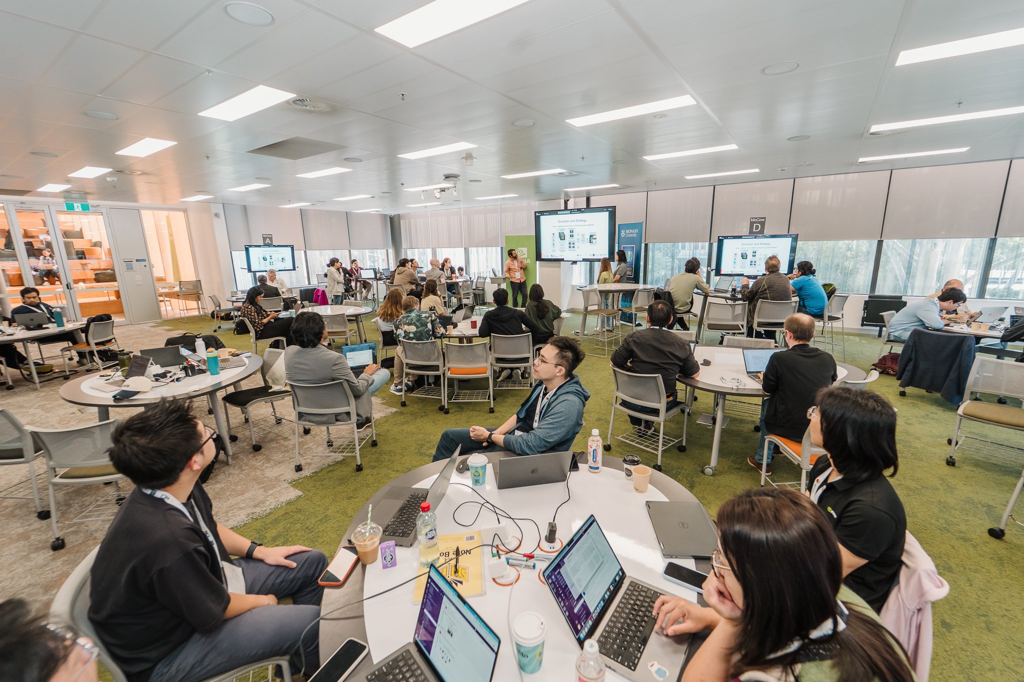People sitting at round desks in a collaborative workspace