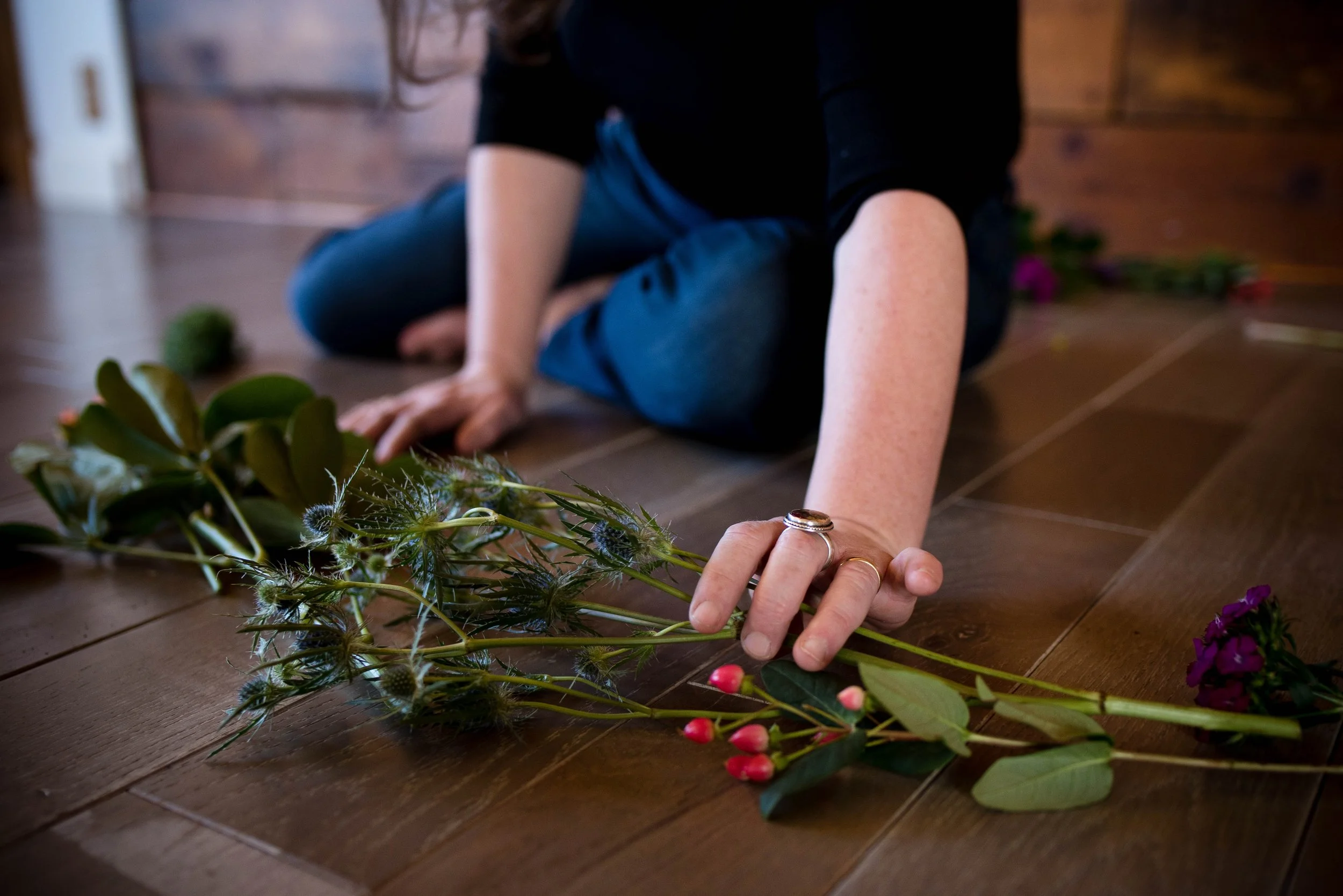 Woman making healing  circle with flowerrs and transforming trauma with depth therapy in Fort Collins, CO