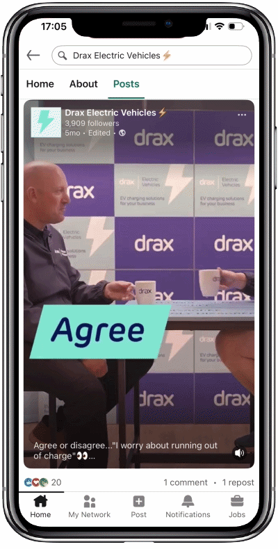 A smartphone showing a social media video of two people sitting across from each other, holding mugs with the Drax logo, discussing electric vehicles. The video overlay has a blue-green caption that says "Agree." The background features a wall with a repeating Drax logo pattern.