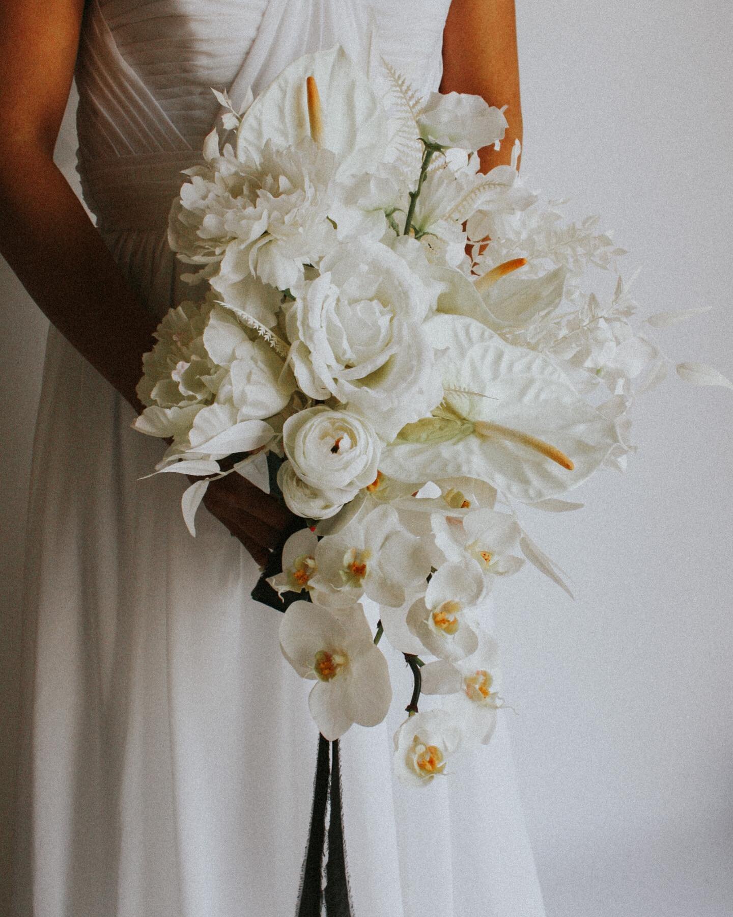 How about this all white cascade bouquet designed with all the good stuff? ANTHURIUMS, PHALAENOPSIS, RANUNCULUS, PEONIES, SWEET PEAS and more! Best part- all artificial/ preserved so you can keep forever 🤍