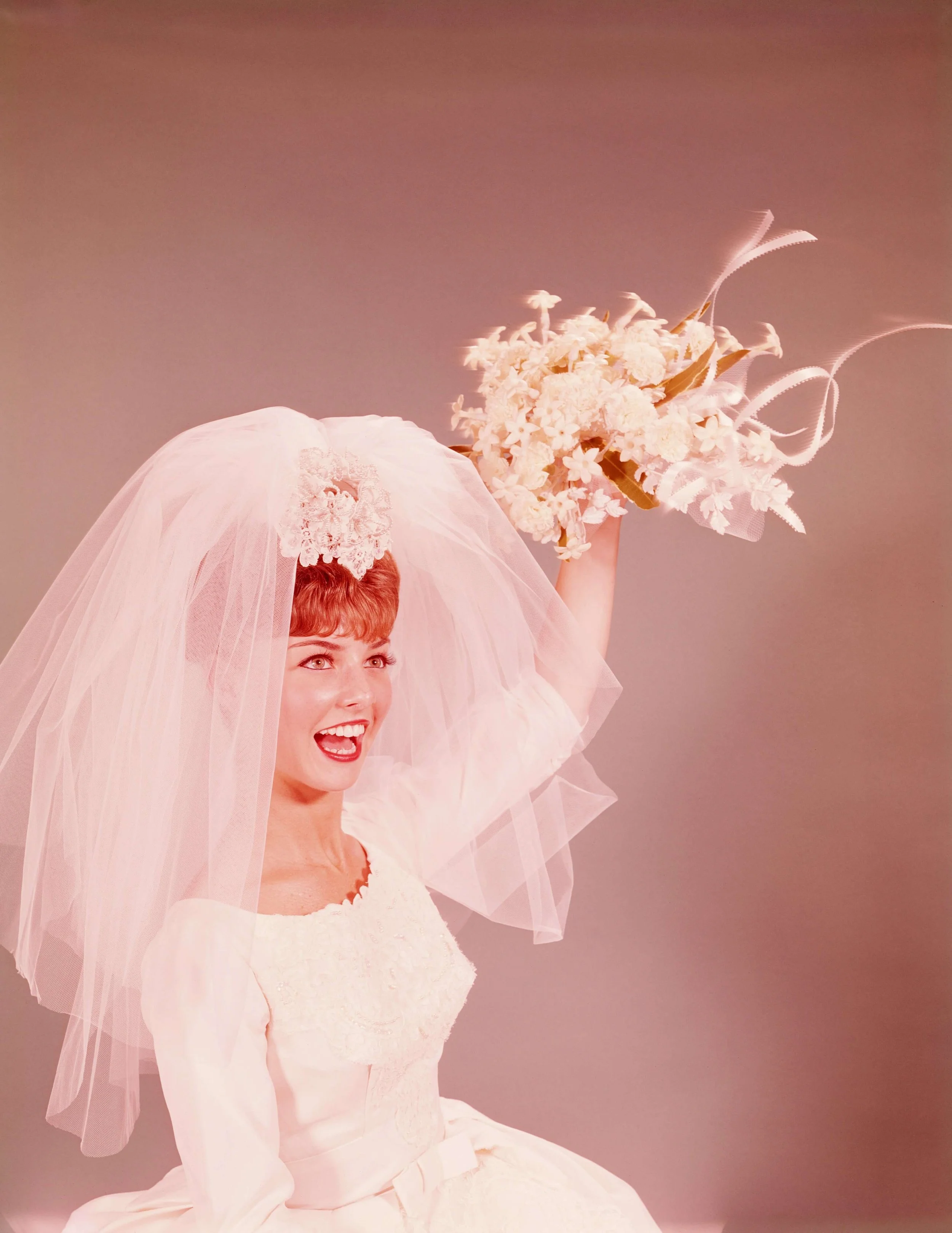 A vintage bride throwing a bouquet