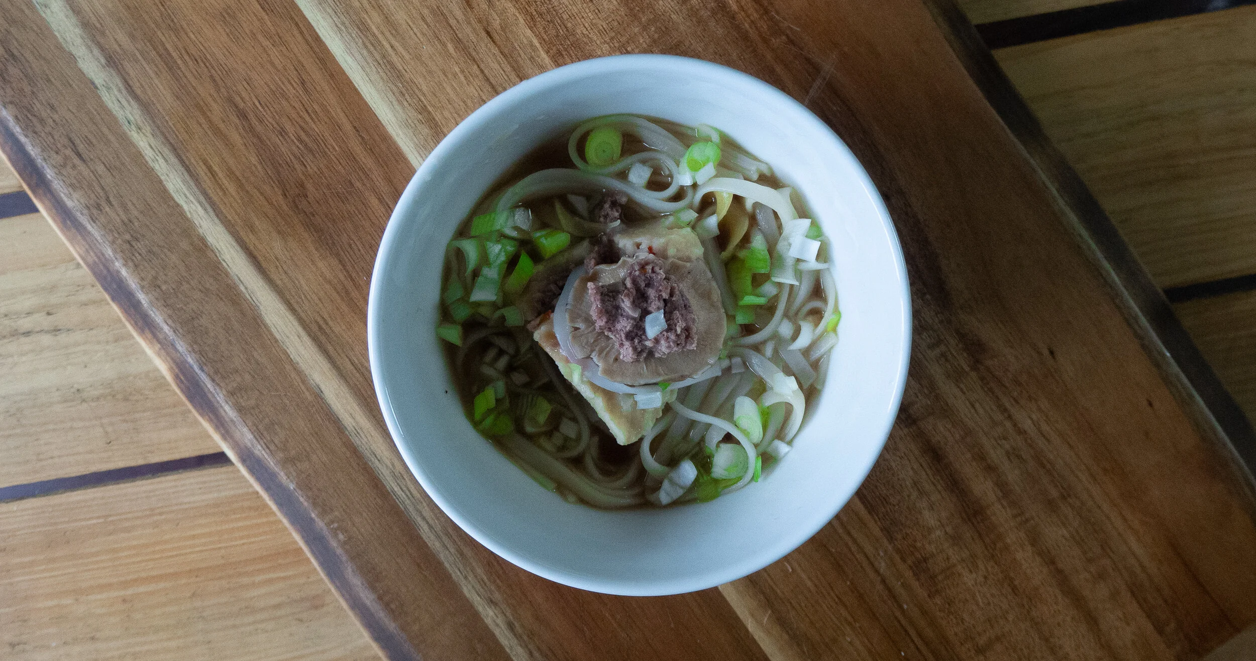 A bisected wonton rests on top of the dish.