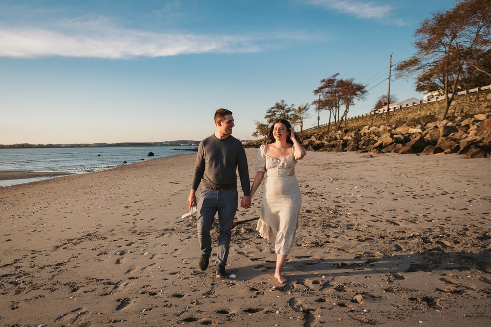 engaged-couple-walking-down-beach.jpg