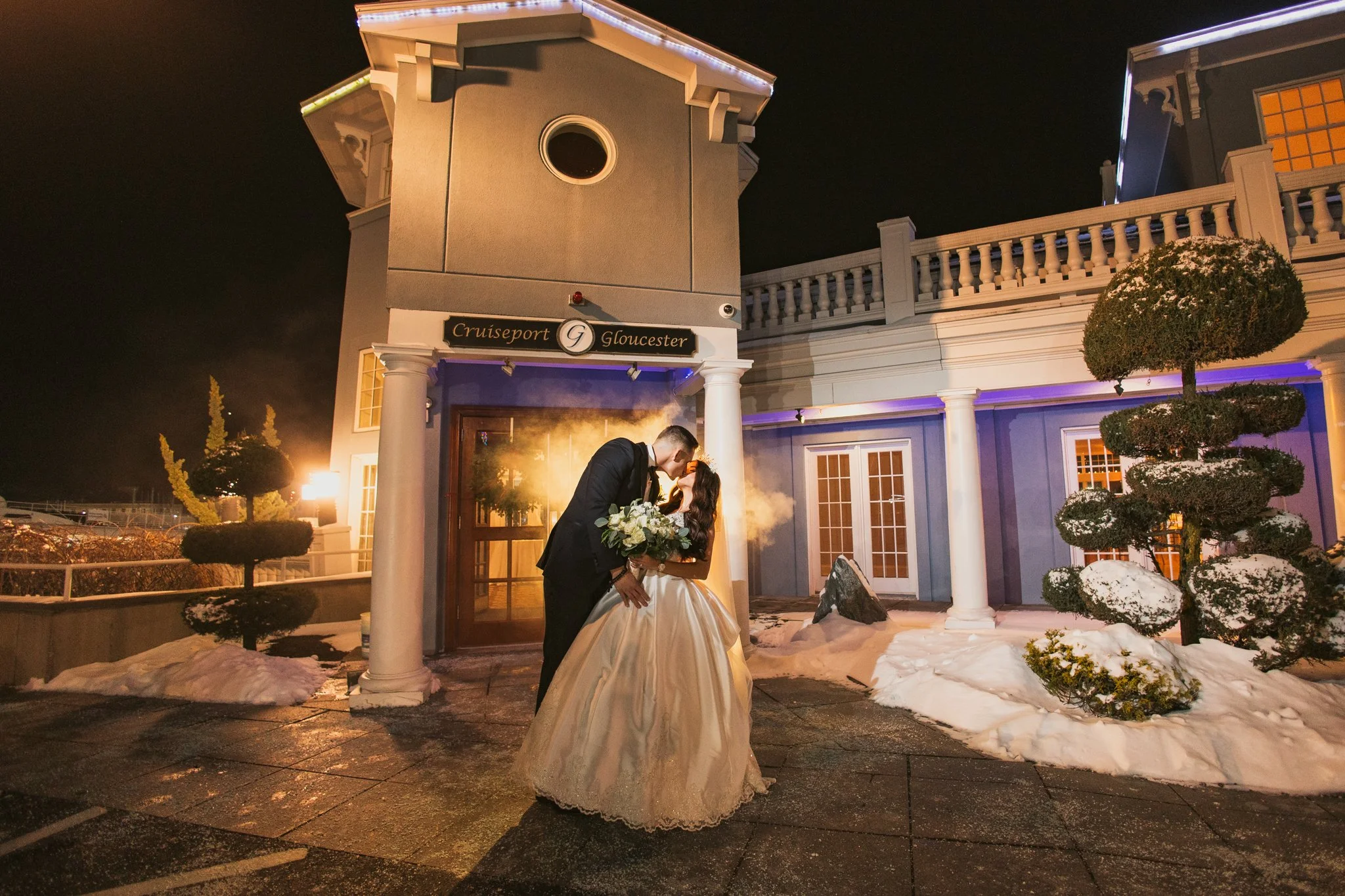 bride and groom night portrait in front of cruiseport gloucester