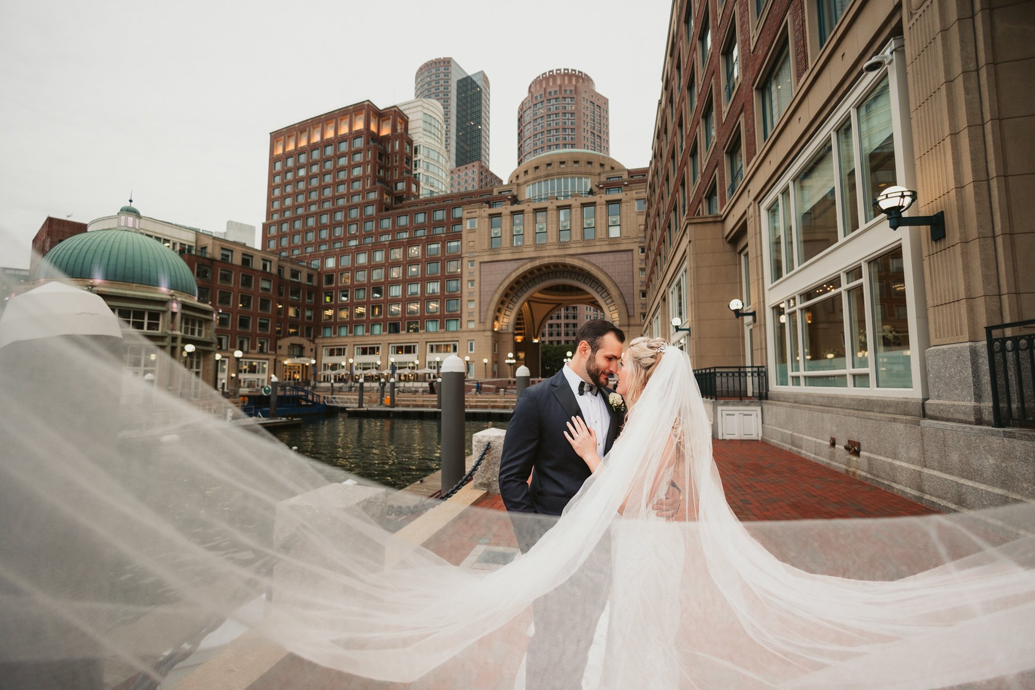 Waterfront wedding portrait at Boston Harbor Hotel with flowing veil