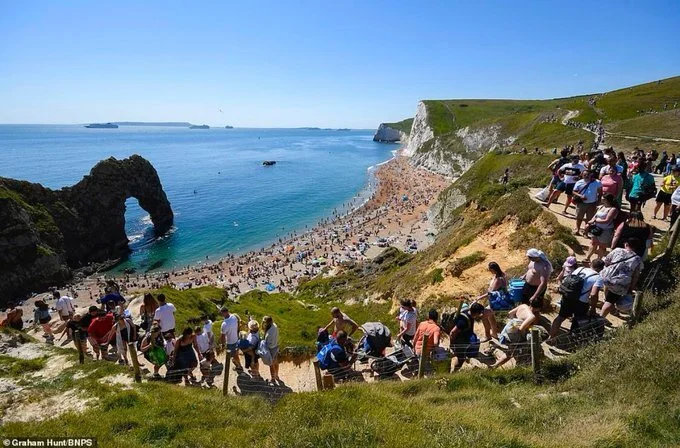 People make their way down to the sea at Durdle Door, Dorset