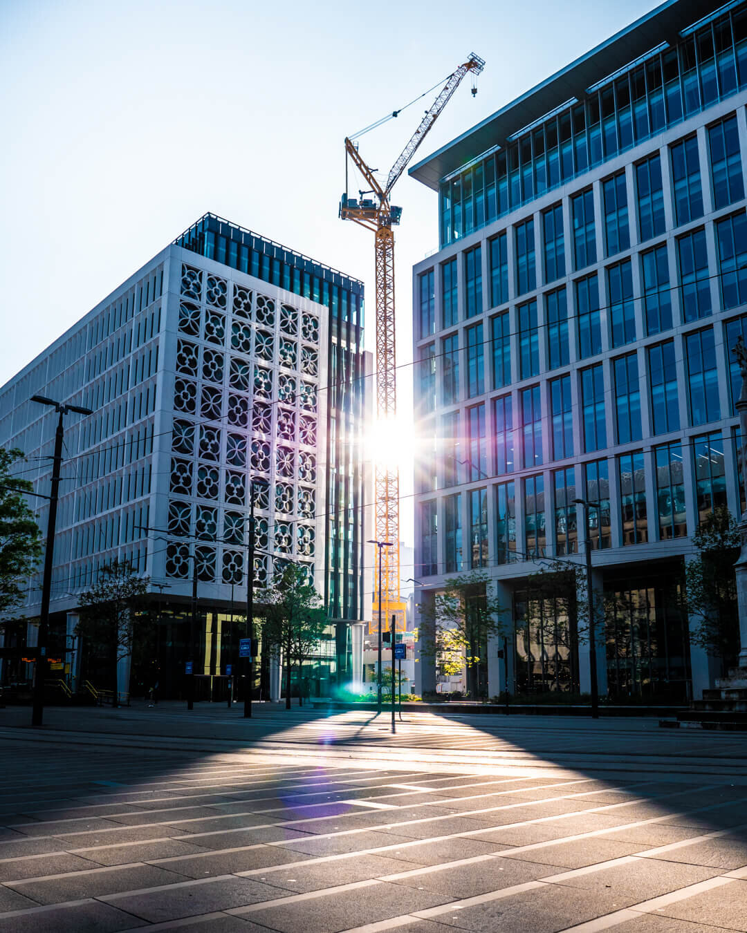St Peter's Square buildings as the sun shines through a crane photography