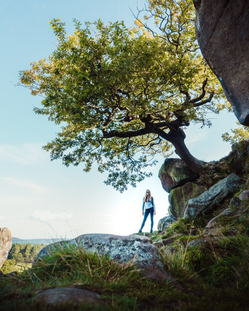 Woman standing next to a tree in the Peak District