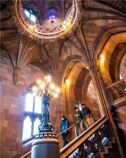 Photography of John Rylands Library from the inside showing tourists walking around and taking pictures