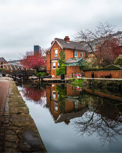 Orange brick house perfectly reflected in the Castlefield canal, Manchester