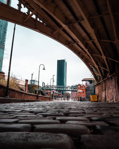 Photography underneath a bridge in Castlefield showing distant buildings