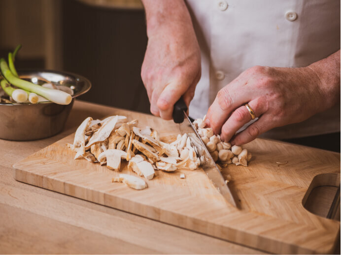 Capturing a chef cutting some mushrooms showcasing the craft and detail that goes into making food in the 1903 lounge