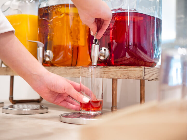 Close-up of a woman pouring herself a glass of cranberry juice 