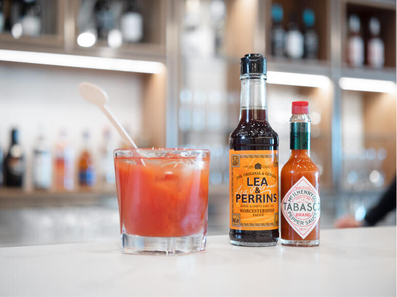 Professional drinks photography capturing a Bloody Mary next to a bottle of Lea &amp; Perrines and Tabasco