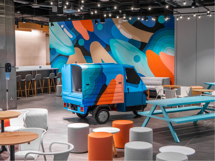 Recaption are at Manchester Airport’s Lounges showing a vibrant abstract wall mural, a small food truck and seating area