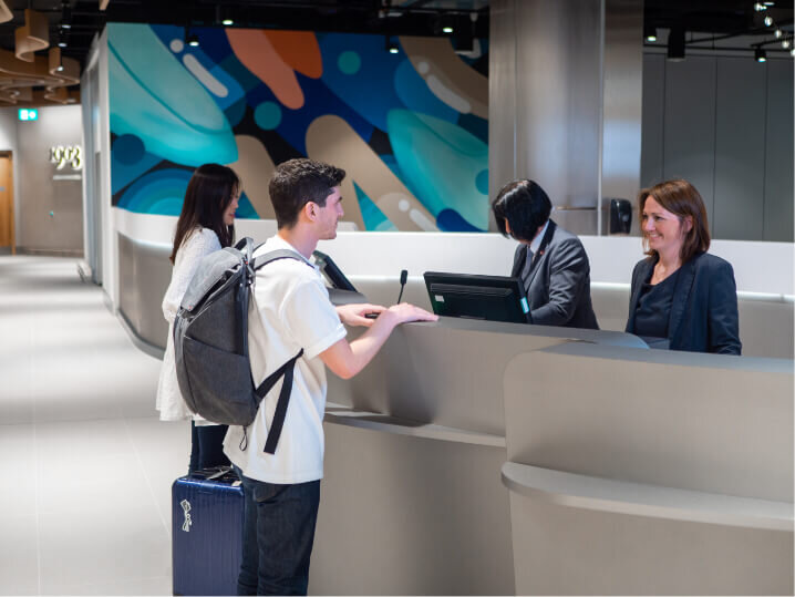 Photography showing two passengers checking in at reception 