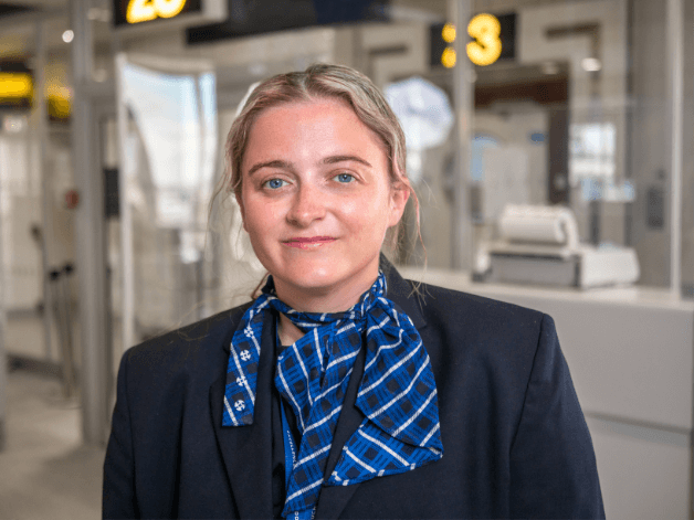 Happy, young flight attendant photographed by the boarding gates at East Midlands