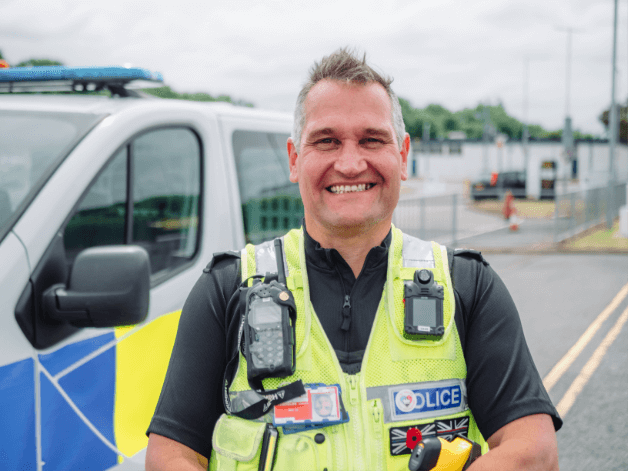 Smiling police officer standing next to his truck at East Midland Airport