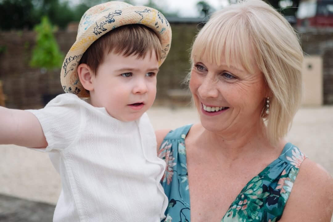 Close up of a grandmother holding her grandson at a wedding