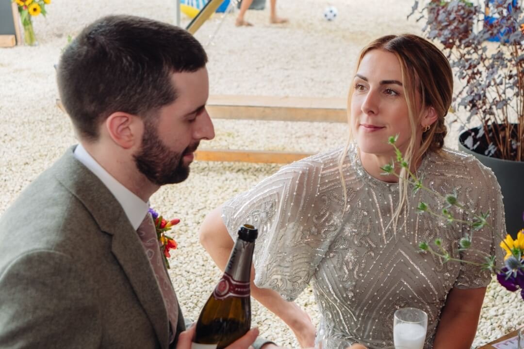 Bride and groom sharing a moment with champagne at wedding reception