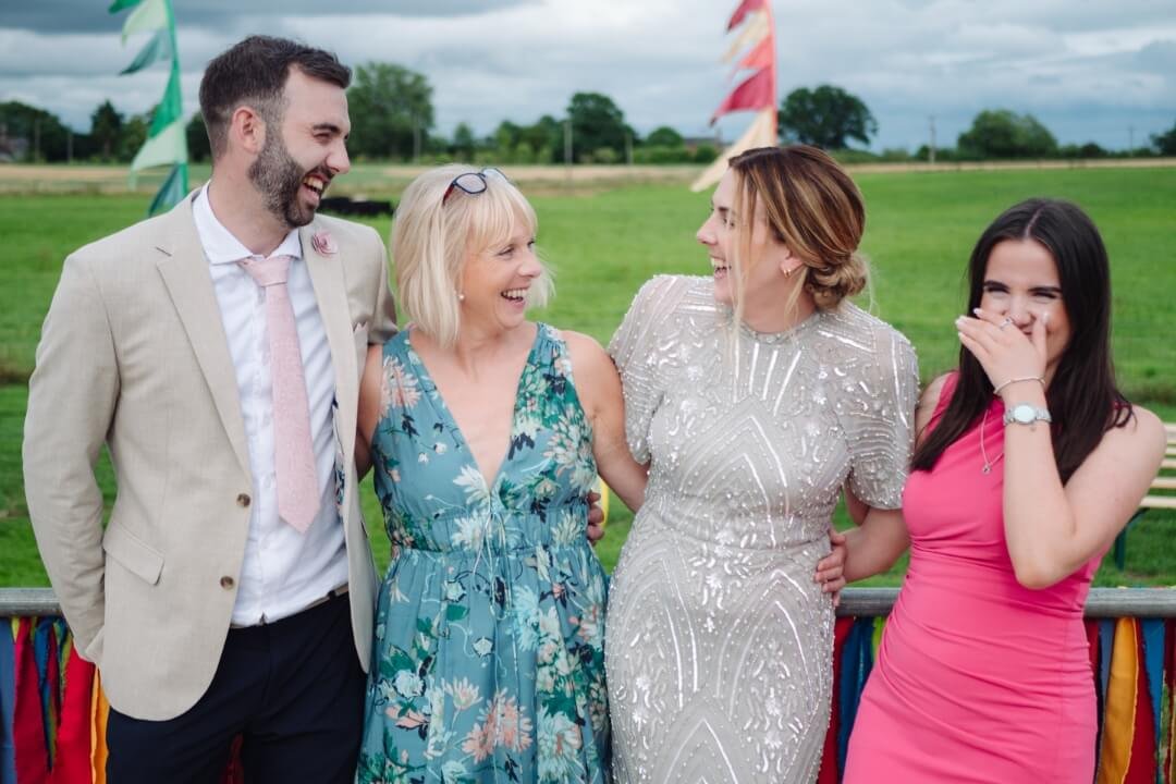 Bride laughing with family and friends during outdoor wedding celebration