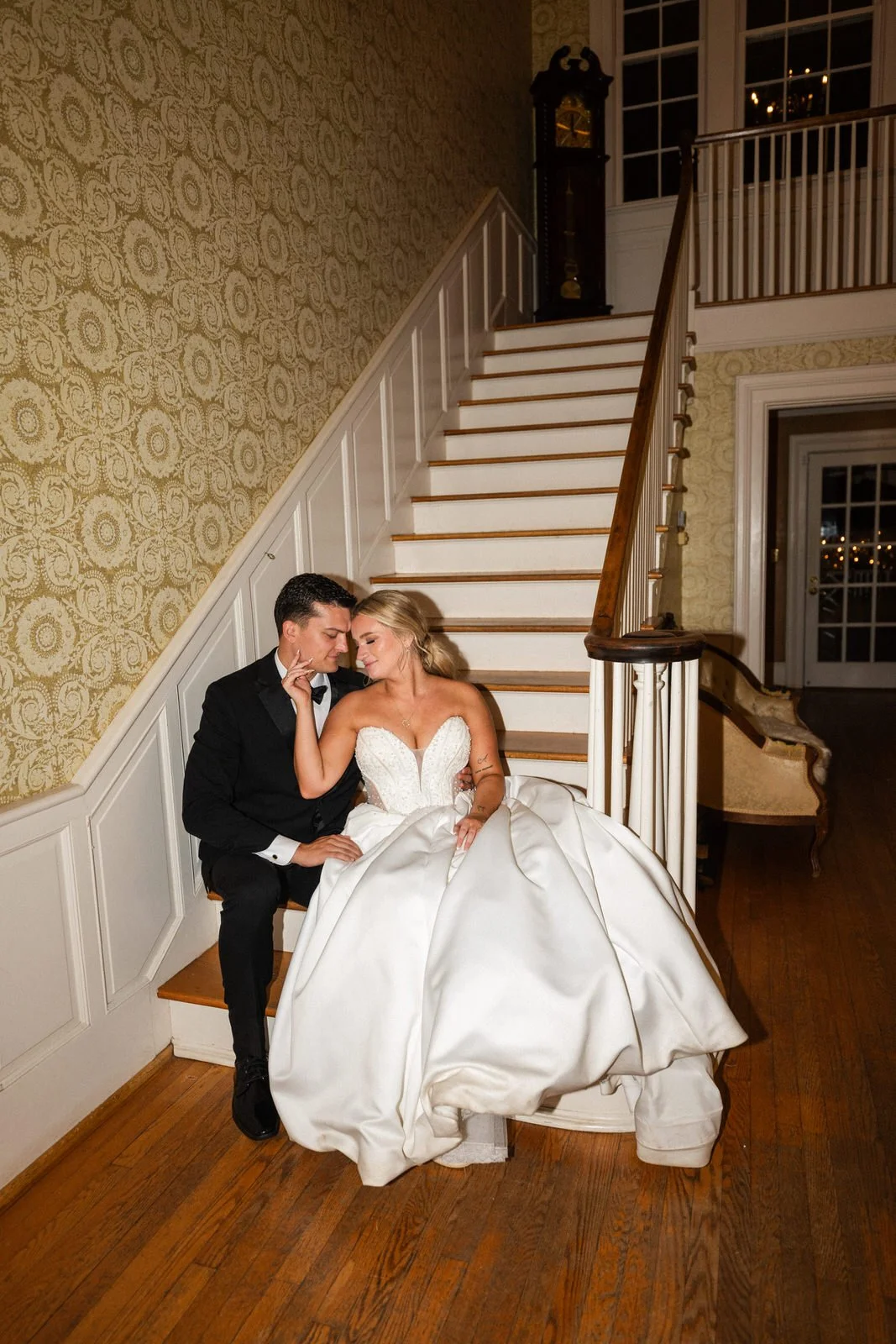 Bride and groom sitting together on the historic staircase inside Duncan Estate in Spartanburg, SC.