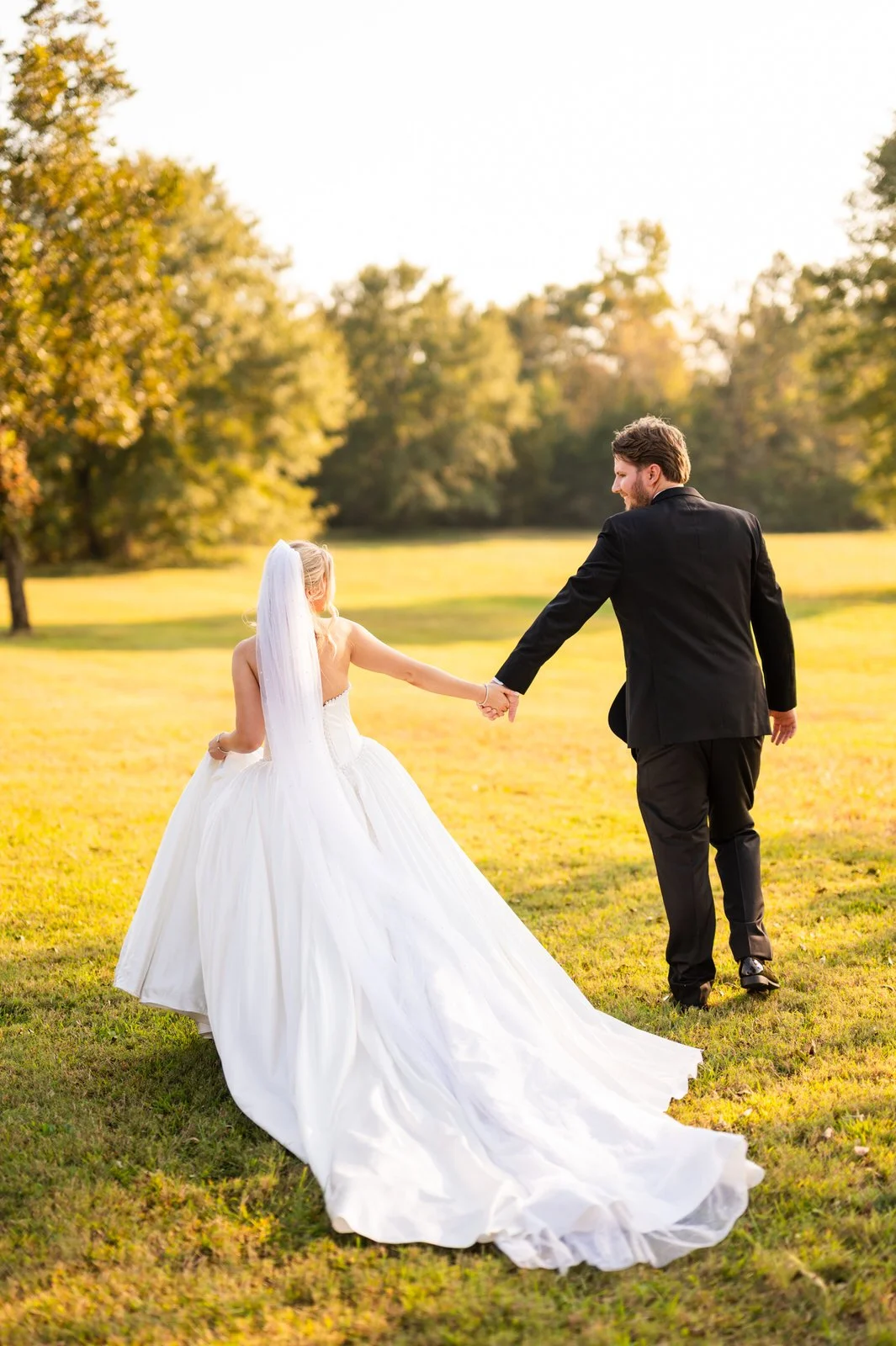 barn-at-sitton-hill-newlyweds-walking-sunlit-field