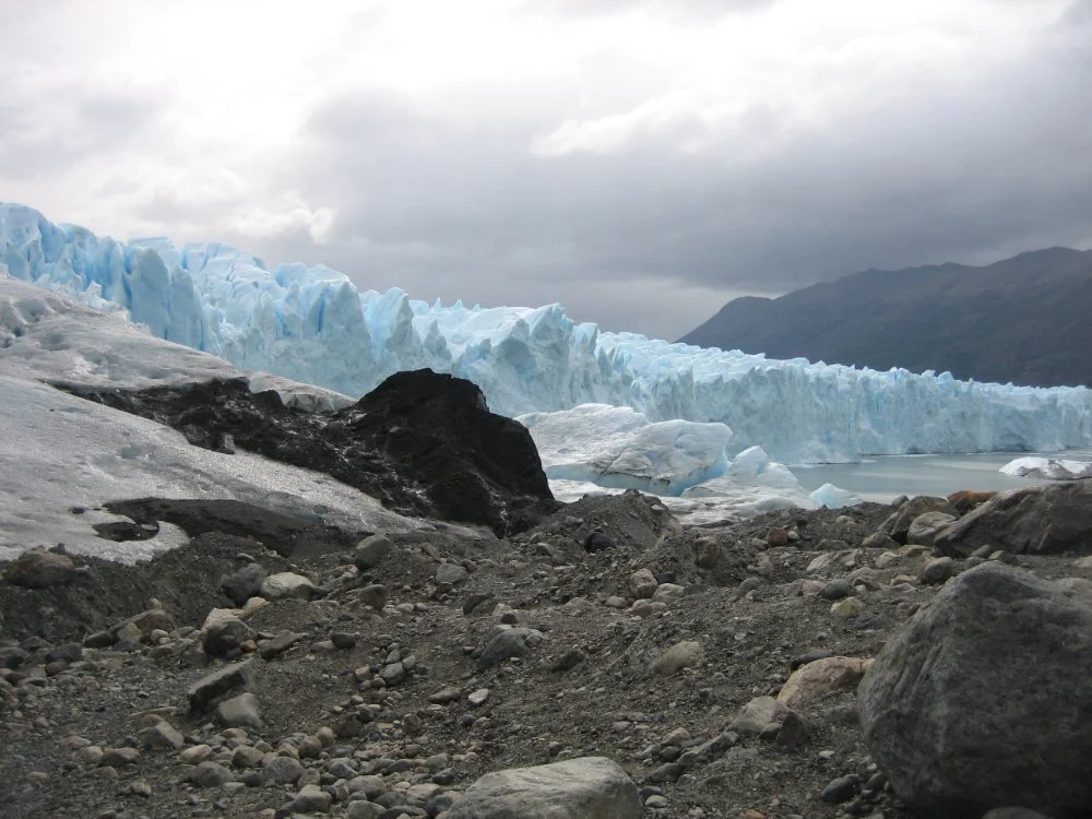 Photo of a glacier terminus and bare rock in front of it.