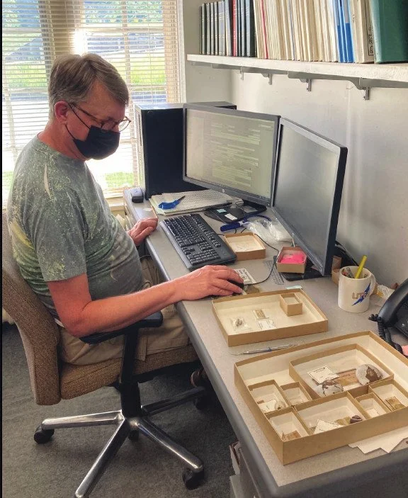 Volunteer, Larry Jensen cataloging specimens.