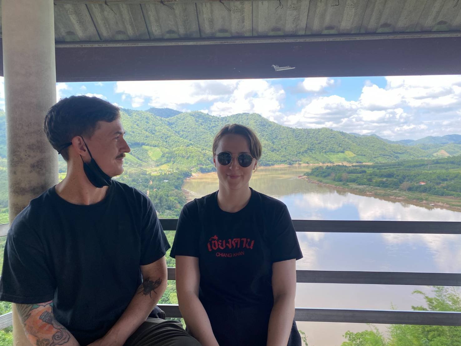 James and Amy sitting in a pagoda with a beautiful view of mountains and a river.jpg