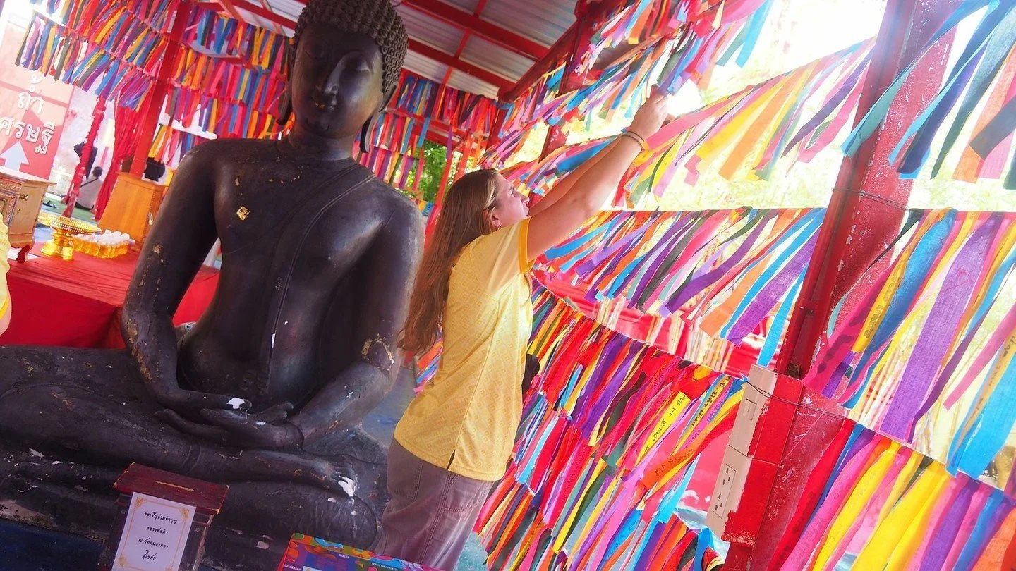 Teacher Nicole stood beneath a sky of rainbow ribbons at the temple in Sukhothai, reaching up to tie her own message of hope among thousands of others. 

Each ribbon carries a dream, a prayer, a quiet thank you.
Hers just joined the most beautiful co