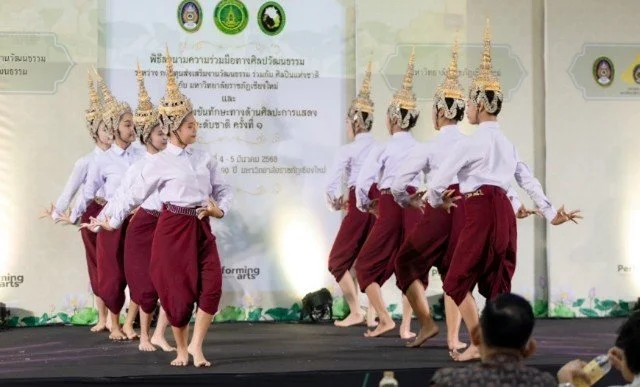 Kids English Thailand Image-Group of performers in traditional Thai costumes dancing on stage.