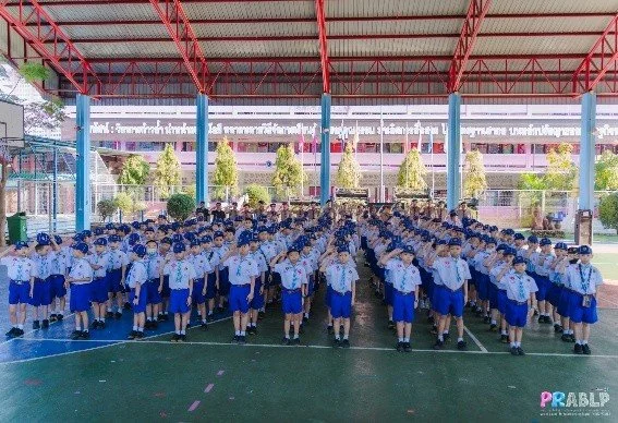 Kids English Thailand Image-Large group of students in uniform standing in formation under a covered outdoor area, likely at a school or event.