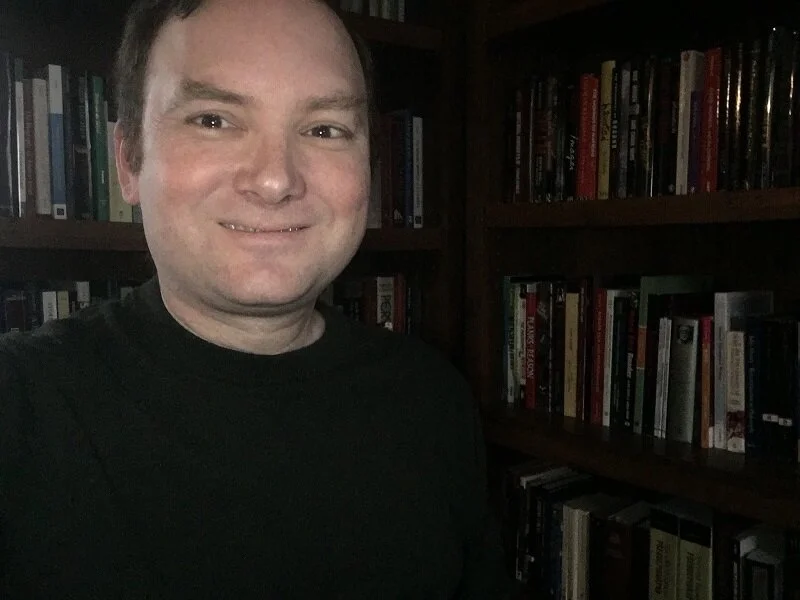 Dr. Grafius in his home office, where his personal library intersects between Bible and horror studies.