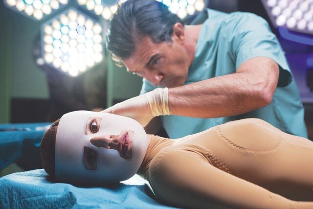 A surgeon examines a woman's face.