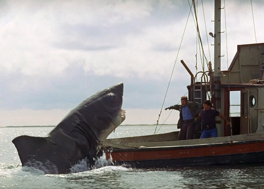 An enormous shark comes out of the water and onto the stern of a small fishing boat in "Jaws."