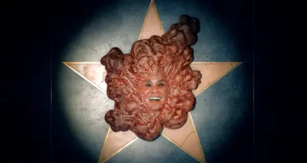 Image of a disgusting blob of flesh with a smiling face laying on top of a star on Hollywood's Walk of Fame.