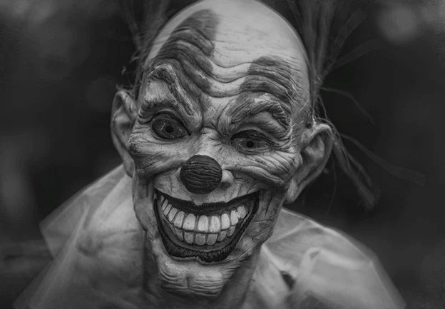 Black and white image of a scary clown mask.