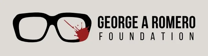 Logo of George A. Romero Foundation featuring black glasses with blood splatter on the right lens, and text to the right.