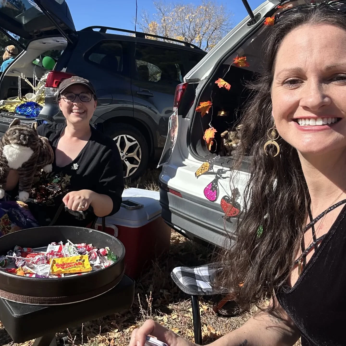 What a blast! Thanks @autismcommunitystore for another great Trunk or Treat! 

[Image description 1: Bonnie and Colleen taking a selfie by a drum filled with candy and a festive trunk. Bonnie is holding a realistic cat puppet.]
[Image description 2: 