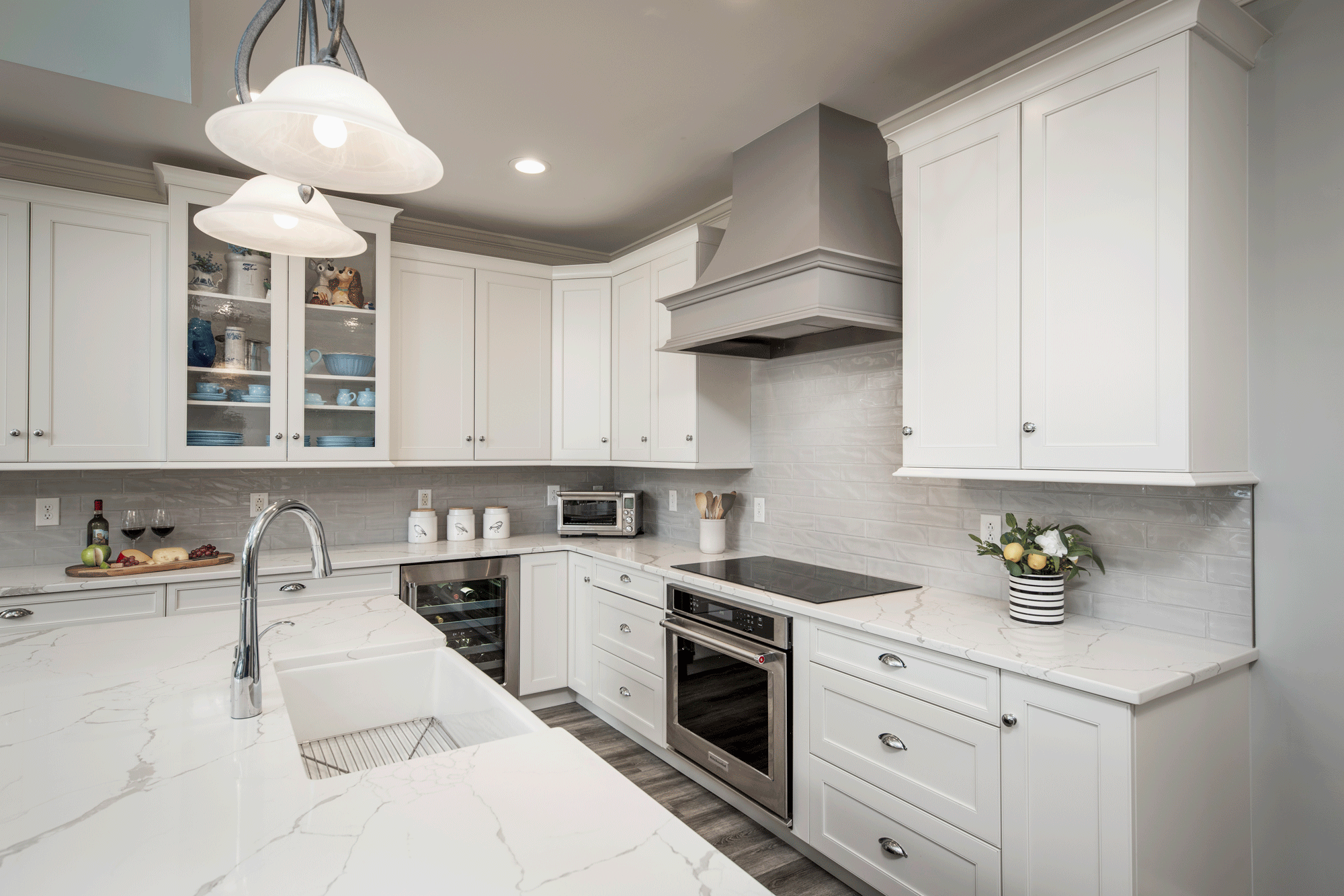 sleek kitchen remodel with flooring, cabinets, pendant lighting, recessed lighting, tile backsplash, island, seating