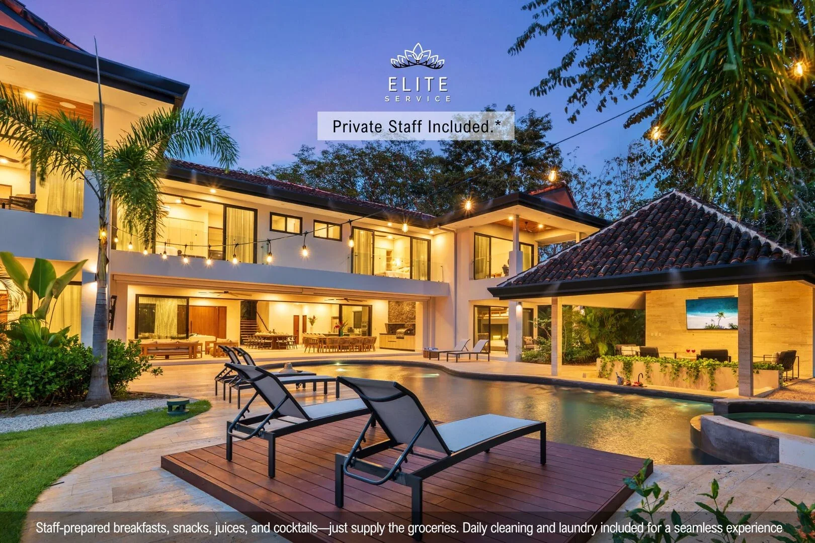 Luxury house with outdoor pool and patio area, illuminated by string lights, surrounded by lush tropical plants and trees.