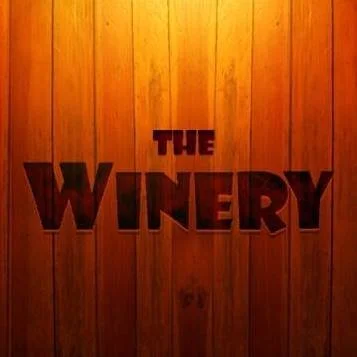Wooden wall with the words "THE WINERY" in large dark letters.