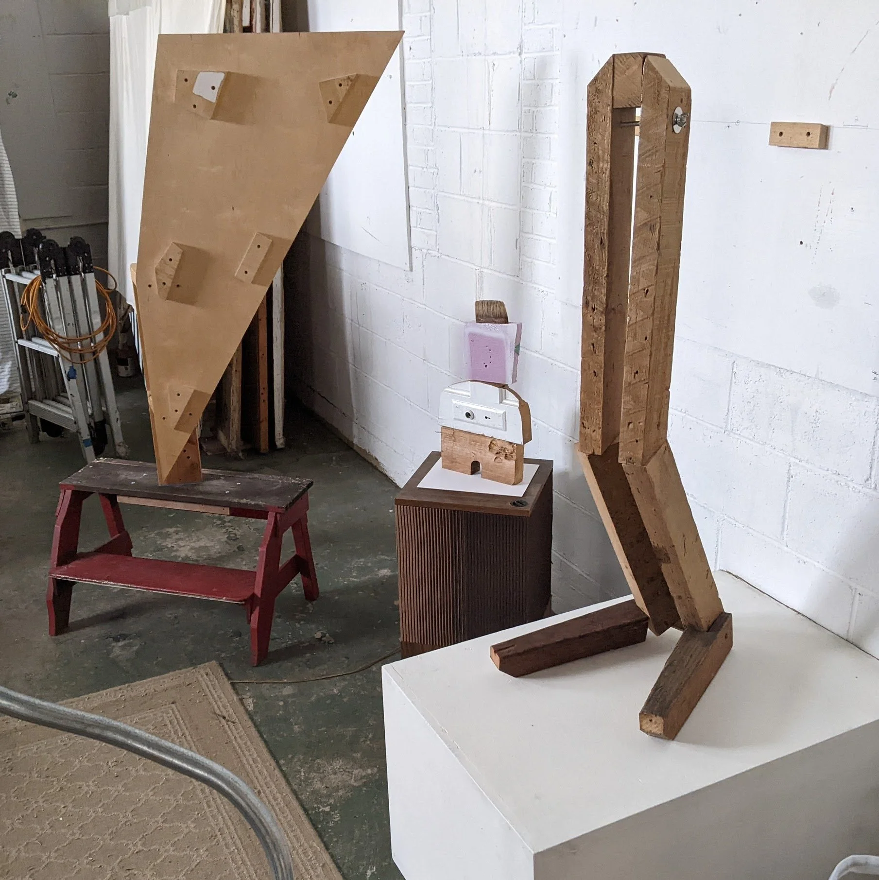   Studio View of 3Recent Objects L-R ,   Figurehead Shaped After Ellsworth Kellys’ “Lake”, Brush-cut, and Knees Bent , 2025 