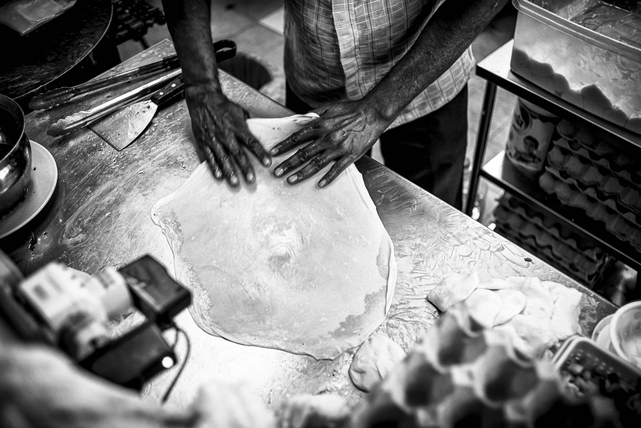 Roti prata is made by flipping the dough repeatedly into a thin layer then folding the dough inwards into its flat bread before sending it to the frying pan.