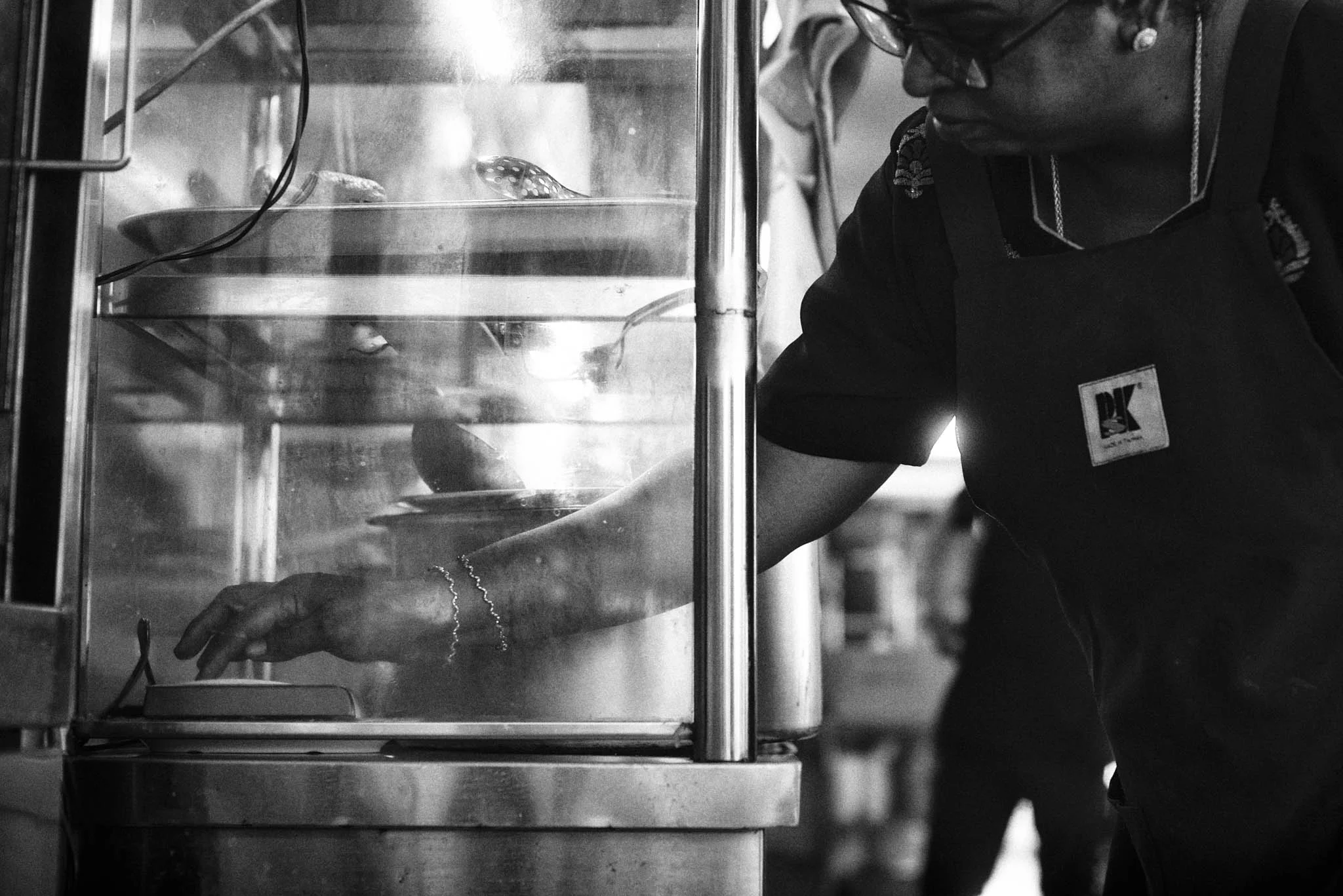 Mrs Mohgan moves quickly between ladling curry to packing pratas to pressing the buzzer for the counter.