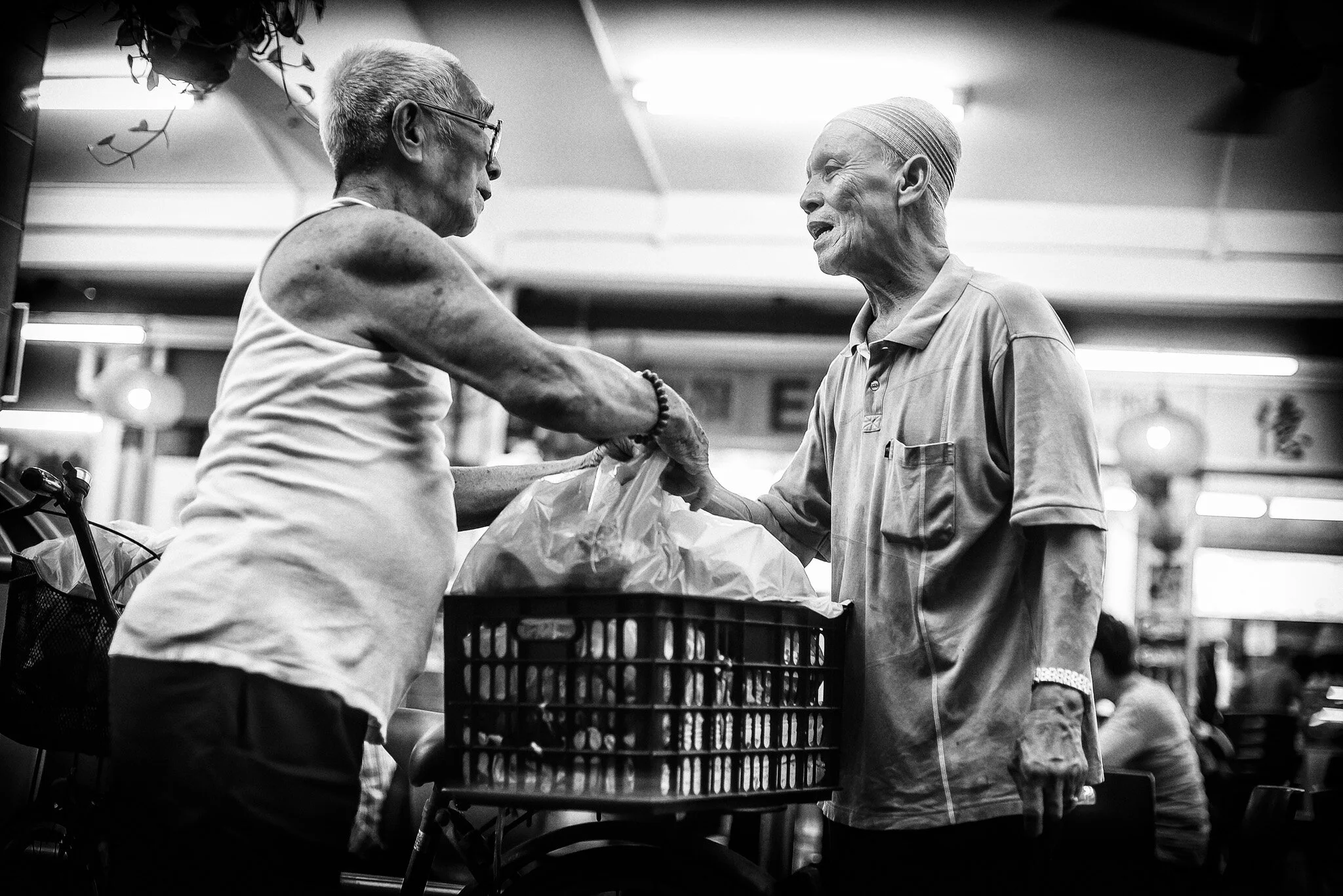 Mr Mohd Tahir Omar greets a regular customer, who buys more than 20 packets of nasi lemak daily to distribute to the needy.