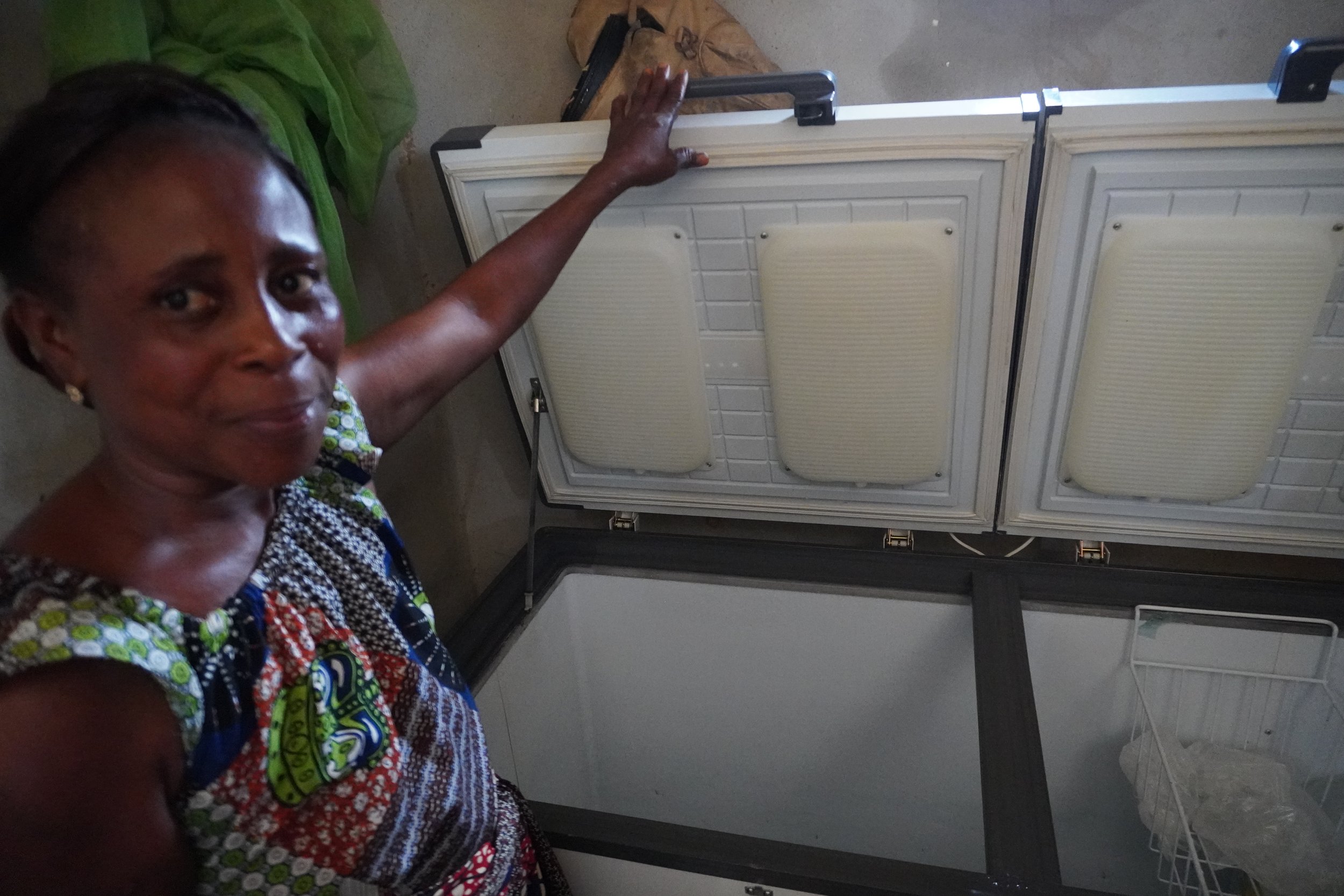  Charlotte Wadé enthusiastically shows the inside of the solar freezer where the AFDD women can store fish. It also allows them to make ice, which is essential for preserving fish until they reach the market: " Often, we have to wait for the tricycle