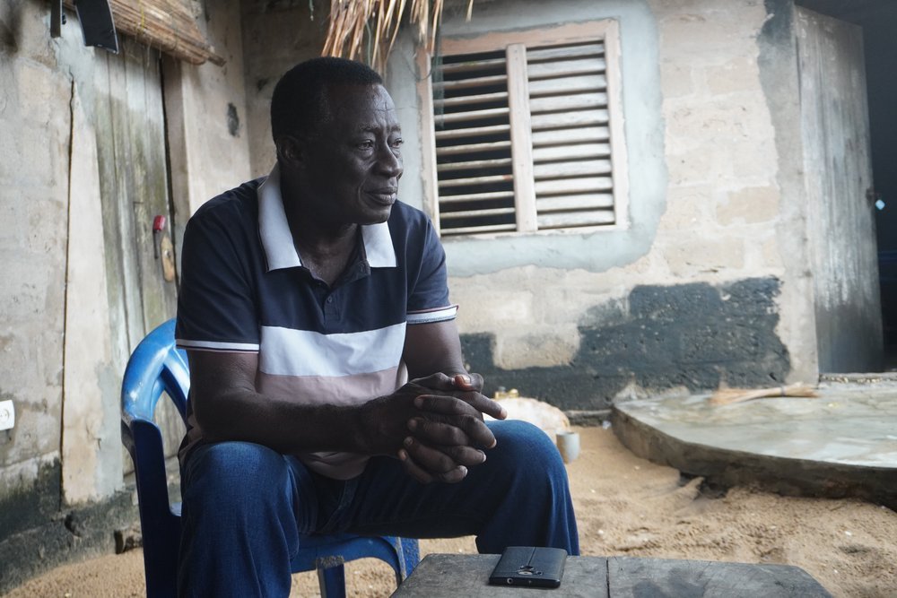  Olivier Aligbo Kome, sitting in his courtyard after a heavy rain, is the chief of the village of Ayiguinnou as well as the fishing chief in the Mono department. As chief, he is present at the departure and return of the pirogues and manages conflict
